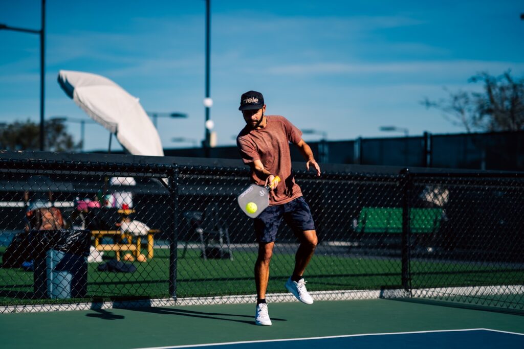 Man playing pickleball on an outdoor court during a match.